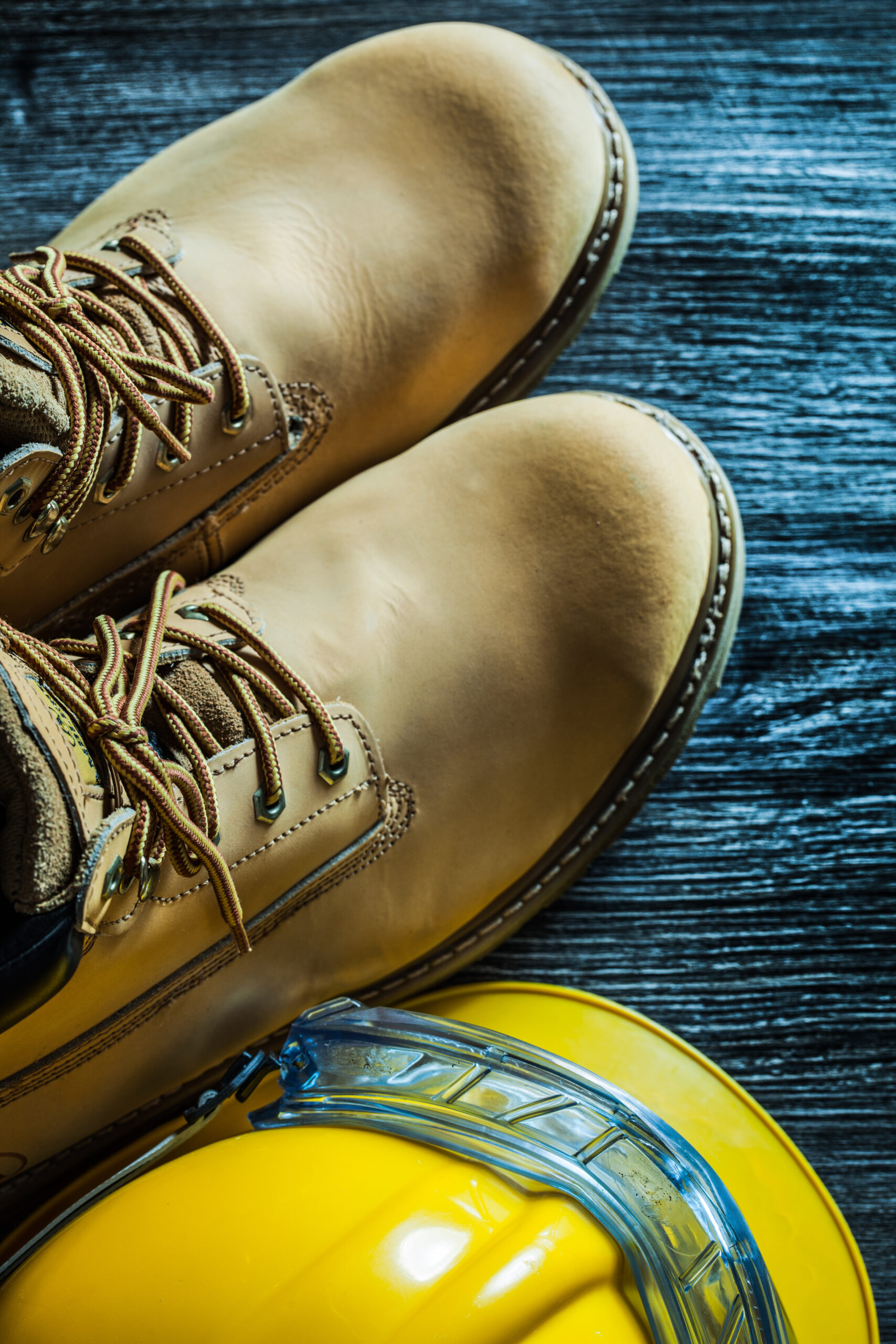 Safety boots cap goggles on vintage wooden board